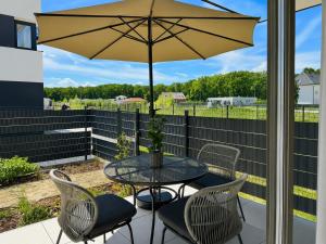 a patio with a table and chairs and an umbrella at Small Garden Apartman in Sárvár