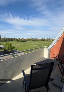 a balcony with a chair and a table and a field at Ferienwohnung Fortuna in Borkum