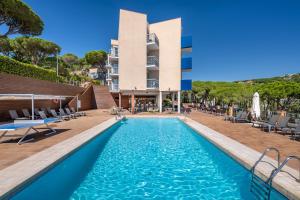 a swimming pool in front of a building at GHT S'Agaró Mar Hotel in Sant Feliu de Guíxols