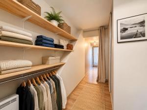 a walk in closet with wooden shelves and towels at Villaloha - Appartement avec terrasse in Bray-Dunes +1 photo