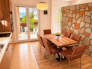 a kitchen and dining room with a wooden table and chairs at Lake and Mountain Hideaway in Ohrid