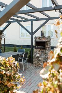 a patio with a fireplace and a table and chairs at Dworek Karwia u Ewy Wiosenna 10 in Karwia