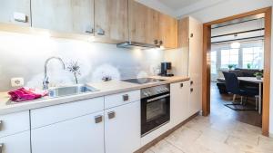 a kitchen with a sink and a stove at Haus an der Pferdekoppel Nr 3 in Fehmarn