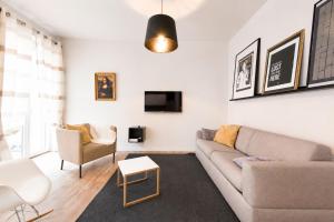 a living room with a couch and a tv at F2 balcon à 1minute de la plage in Saint-Raphaël