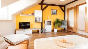 a living room with a yellow accent wall at Haus an der Pferdekoppel Nr 2 in Fehmarn