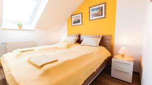 a bedroom with a large bed with a yellow wall at Haus an der Pferdekoppel Nr 2 in Fehmarn