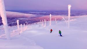 two people skiing down a snow covered ski slope at Levin Kalle Apartment in Levi