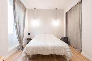 a bedroom with a bed in a white room at F2 balcon à 1minute de la plage in Saint-Raphaël