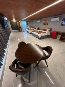 a room with two beds and a table in it at HOTEL NOVO CENTRO in Petrolina
