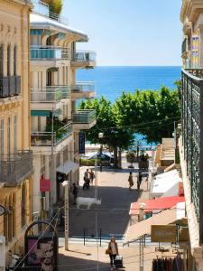 a view of a street with a building and the ocean at F2 balcon à 1minute de la plage in Saint-Raphaël