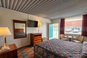 a hotel room with a bed and a television at Carolina Inn Anderson Clemson Area in Anderson