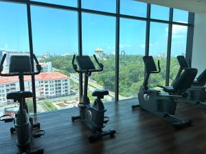 a gym with cardio equipment in a large room with windows at Kuching Kozi Square 2paxs Large Window CityView Infinity Pool 2E in Kuching