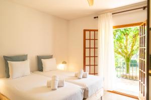 two beds in a room with a window at Majordoms Vila in Cornellá de Terri +42 photos