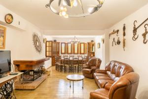 a living room with leather furniture and a dining room at Majordoms Vila in Cornellá de Terri