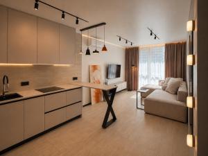 a kitchen and living room with a table and a couch at Great Apart - Вид на Дніпро - 6 поверх - укриття на території ЖК in Kyiv
