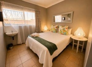 a bedroom with a bed and a sink and a window at Zhantique Guest House 2- Unit 12 in Boksburg