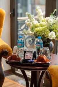 a table with two bottles of water and a vase with flowers at ORA Hotel in Văn La