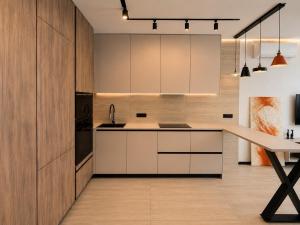 a kitchen with white cabinets and a table at Great Apart - Вид на Дніпро - 6 поверх - укриття на території ЖК in Kyiv +6 photos