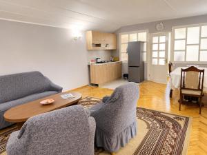 a living room with a couch and chairs and a table at Chkalovka Guest House With Sevan View in Sevan