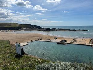 a swimming pool on a beach next to a beach at Bithecutt Cottage in Bude