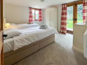 a bedroom with a large bed and a window at The Old Sawmill One - Uk49336 in Plumpton Green +7 photos