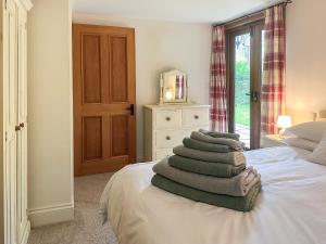 a stack of towels on a bed in a bedroom at The Old Sawmill One - Uk49336 in Plumpton Green