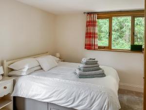 a bedroom with a white bed with a window at The Old Sawmill One - Uk49336 in Plumpton Green