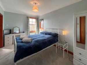 a bedroom with a bed with a blue blanket and a television at Avocet Apartment - Uk51130 in Carradale