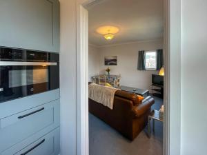a living room with a couch and a kitchen at Avocet Apartment - Uk51130 in Carradale