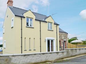 a yellow house with a black roof at Cart-Tws Bach - Om8 in Treffynnon 