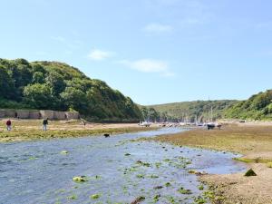 a group of people standing on a beach next to a river at Cart-Tws Bach - Om8 in Treffynnon 