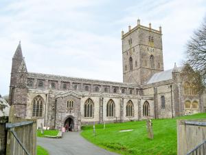a large stone church with a tower and a clock at Cart-Tws Bach - Om8 in Treffynnon 