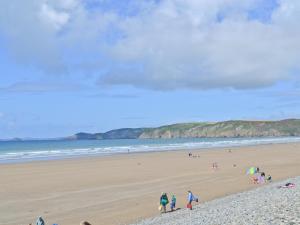 a group of people walking on a beach at Cart-Tws Bach - Om8 in Treffynnon 