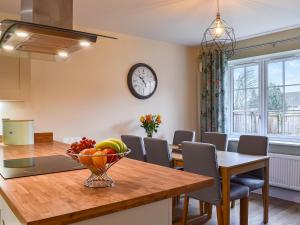 a kitchen and dining room with a table with a bowl of fruit at The Garth in Helmsley