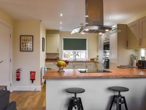 a kitchen with a counter and two bar stools at The Garth in Helmsley