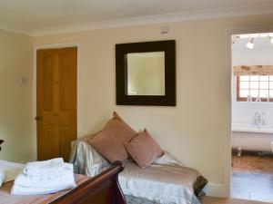 a room with a couch and a mirror on the wall at Boothby Cottage in Willoughby