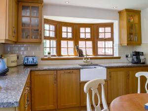 a kitchen with wooden cabinets and a cat sitting on the counter at Boothby Cottage in Willoughby