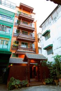 um edifício de apartamentos com um gazebo em frente em Lamphu Tree House Boutique Hotel em Bangkok
