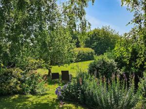two chairs sitting in the middle of a garden at Elm Barn View in Freethorpe