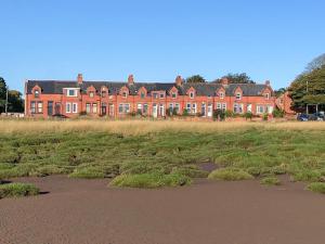 a large red brick building in the middle of a field at The Haven in Annan