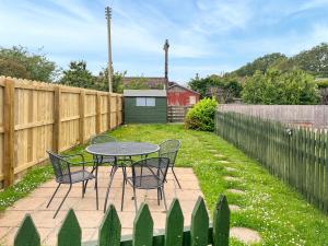 a patio with a table and chairs and a fence at The Haven in Annan