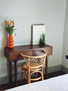 a desk with a vase of flowers and a mirror at Margate Manor - Rooms by the Sea in Margate