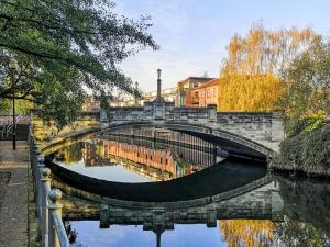 a bridge over a river in a city at Elm Barn Lodge in Freethorpe