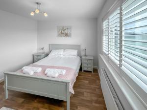 a white bedroom with a bed and a window at Magnolia Lodge - Uk51603 in Peel