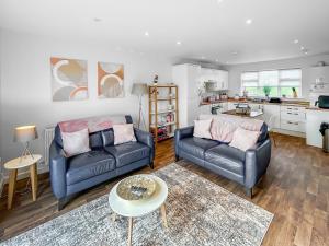 a living room with two couches and a kitchen at Magnolia Lodge - Uk51603 in Peel