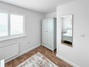 an empty white room with a mirror and a bed at Magnolia Lodge - Uk51603 in Peel