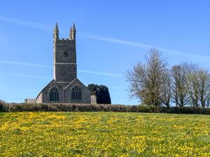 a church in the middle of a field of flowers at Cider Cottage - Uk11861 in North Tamerton