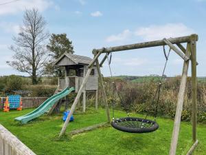 a playground with a swing and a slide at Cider Cottage - Uk11861 in North Tamerton