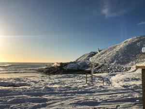 a beach covered in snow with the ocean in the background at Watersreach in Collieston
