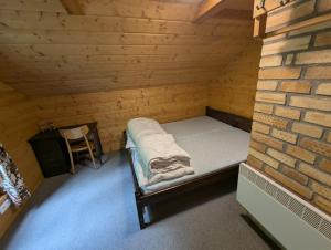a small room with a bed and a brick wall at Chata Oliva in Planá nad Lužnicí